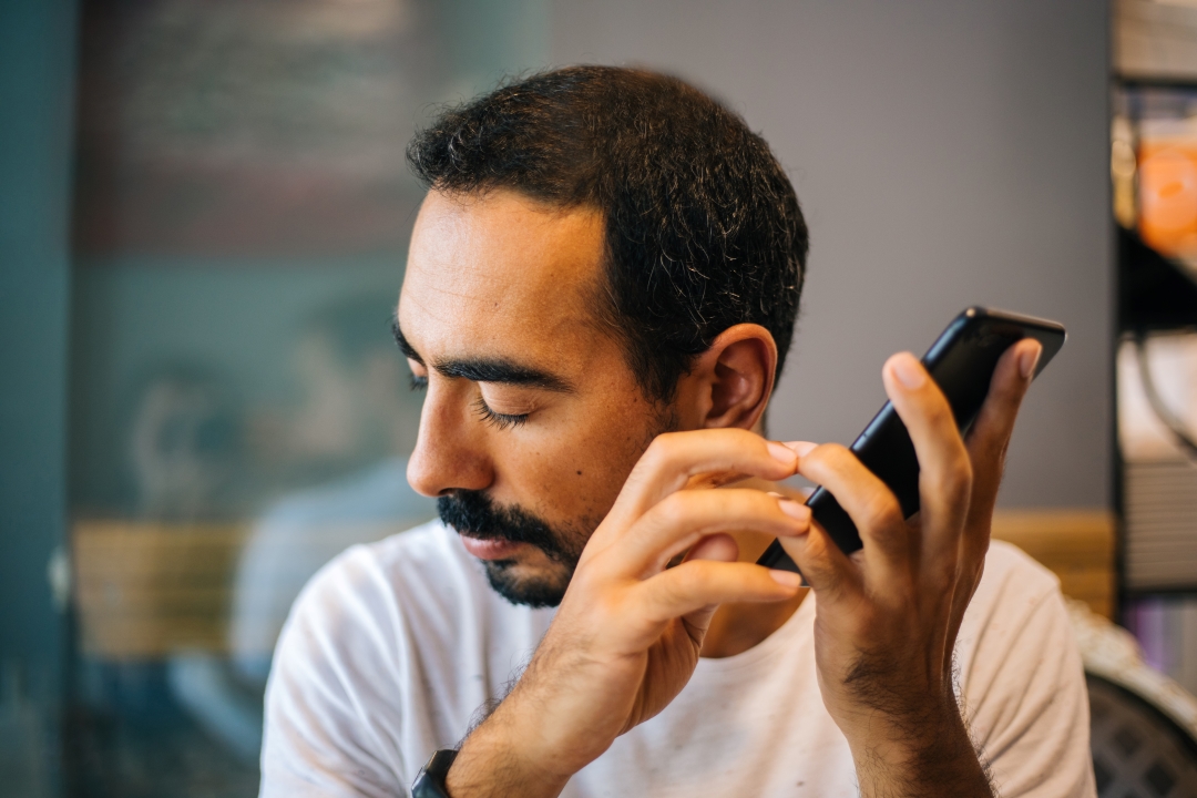 A person listening to a screen reader on a mobile phone